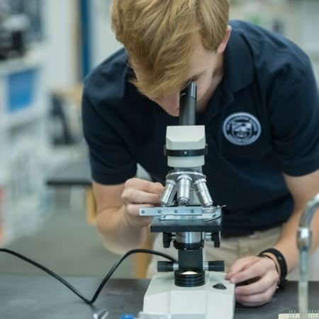 upper school student using a microscope